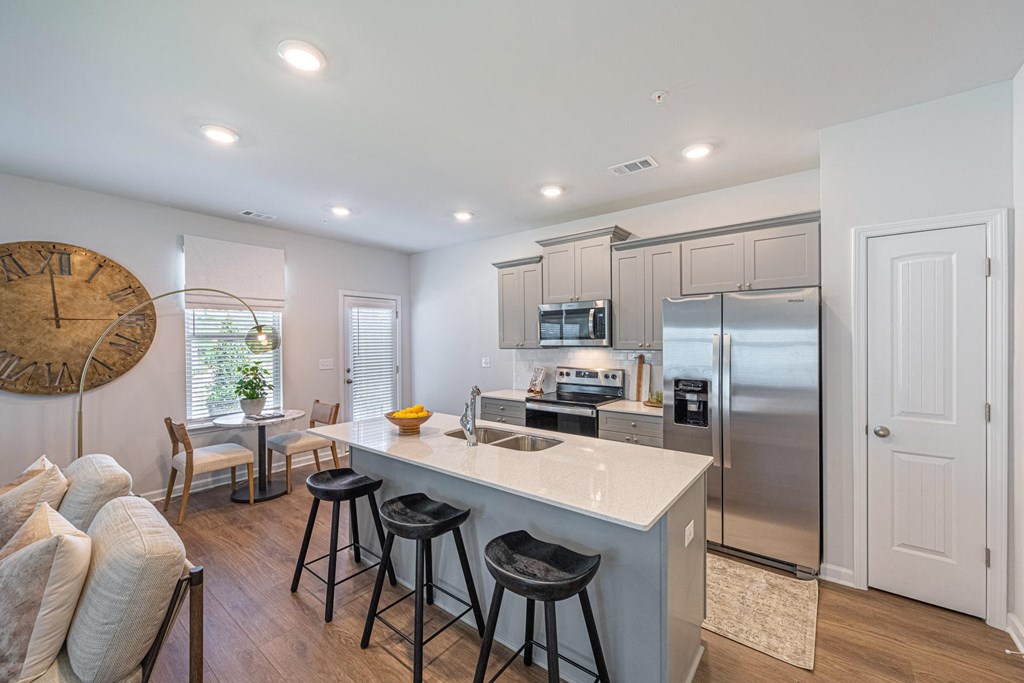 a kitchen with a large island with three stools