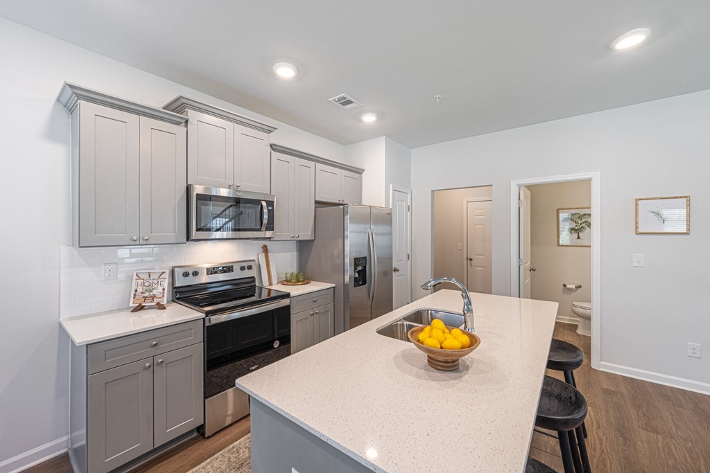 a kitchen with a large island with a bowl of fruit