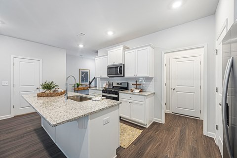 a renovated kitchen with white cabinets and a counter top