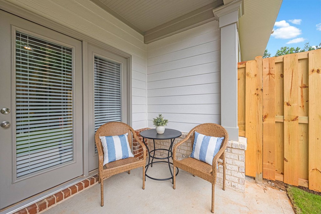 a patio with two chairs and a table on a porch