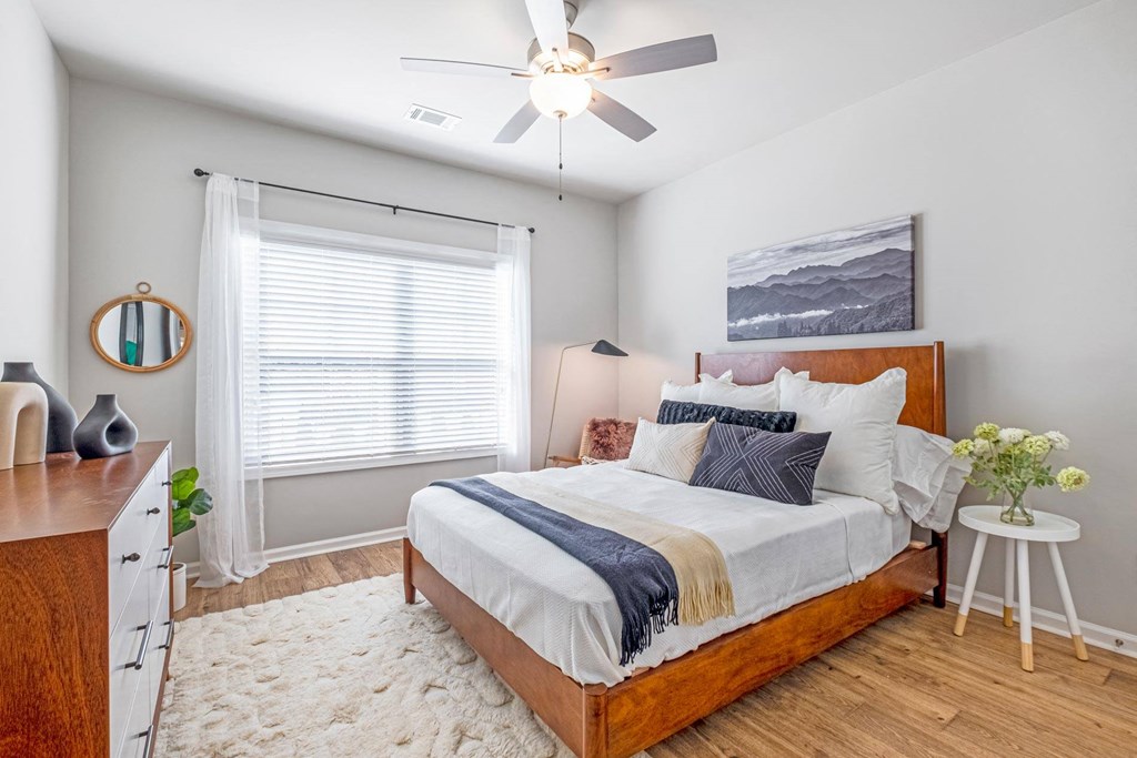 a bedroom with a bed and a ceiling fan