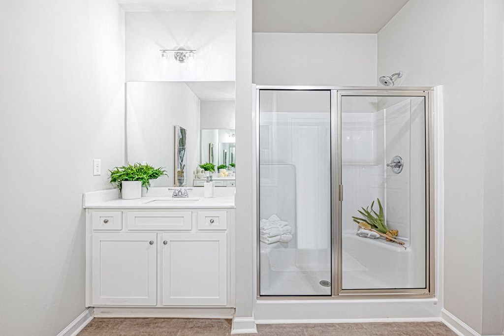 a white bathroom with a shower and a sink