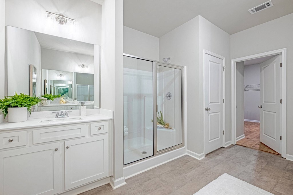 a white bathroom with a shower and a sink