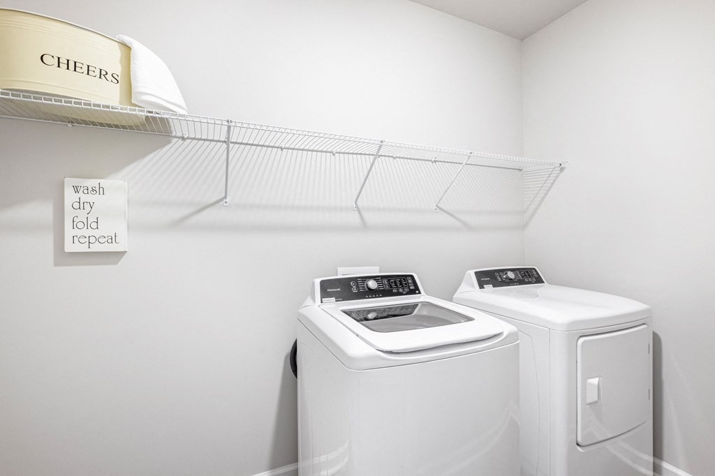 a washer and dryer in a laundry room with a shelf and two white