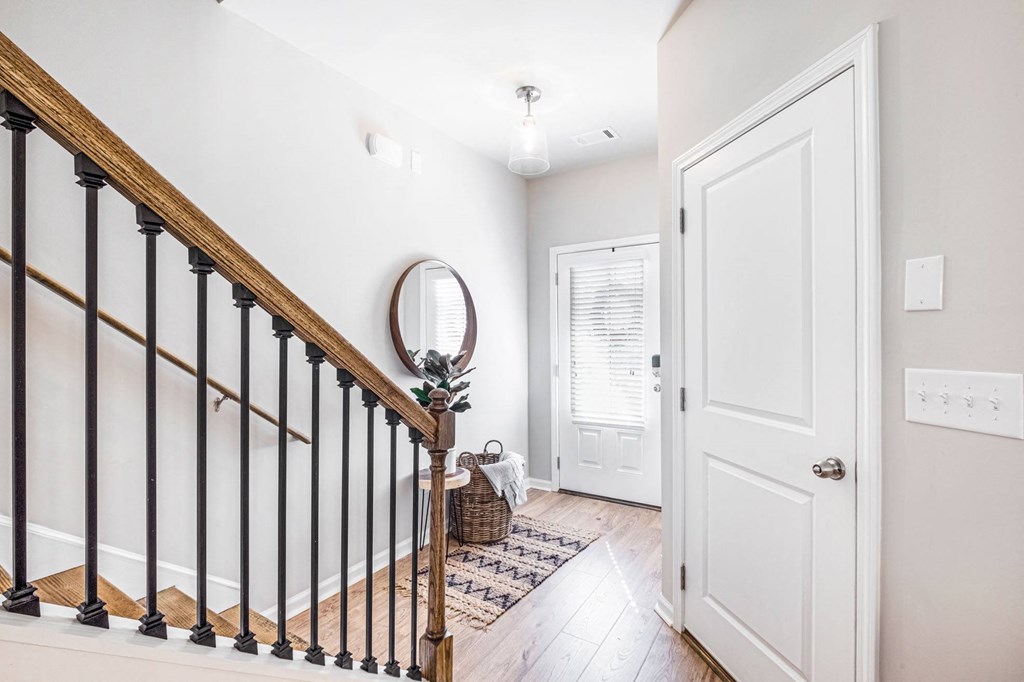 the entrance to a home with a staircase and a white door