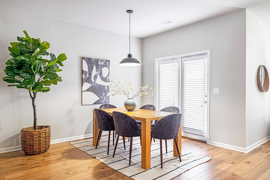a dining room with a table and chairs and a potted plant