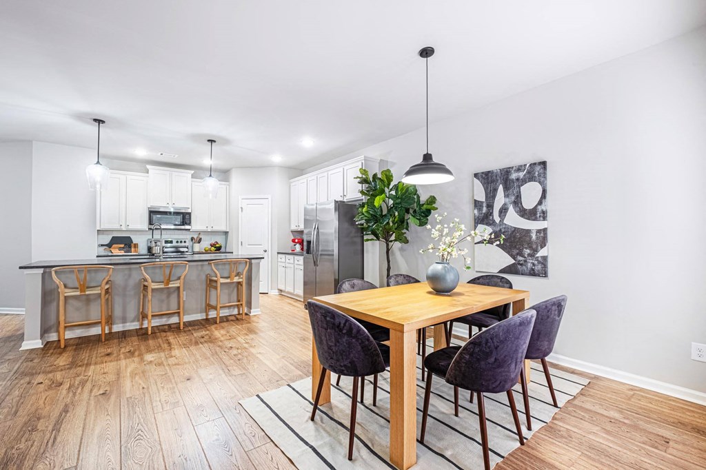a dining room with a table and chairs next to a kitchen