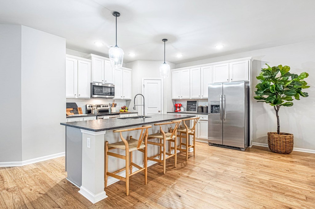 a kitchen with a large island and a stainless steel refrigerator