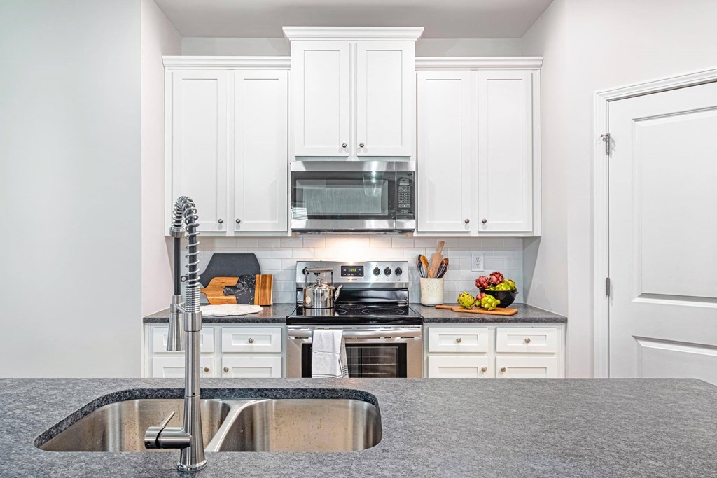 a kitchen with white cabinets and a sink
