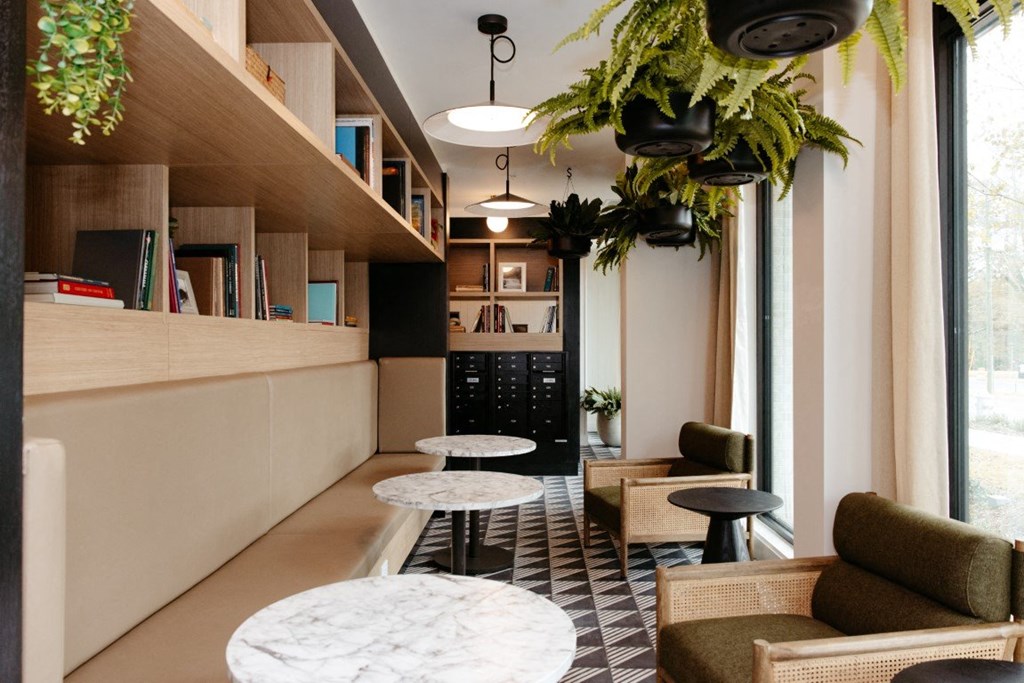 a lobby with tables and chairs and a large window
