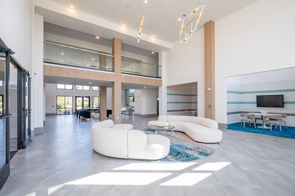 a large living room with white couches and a rug