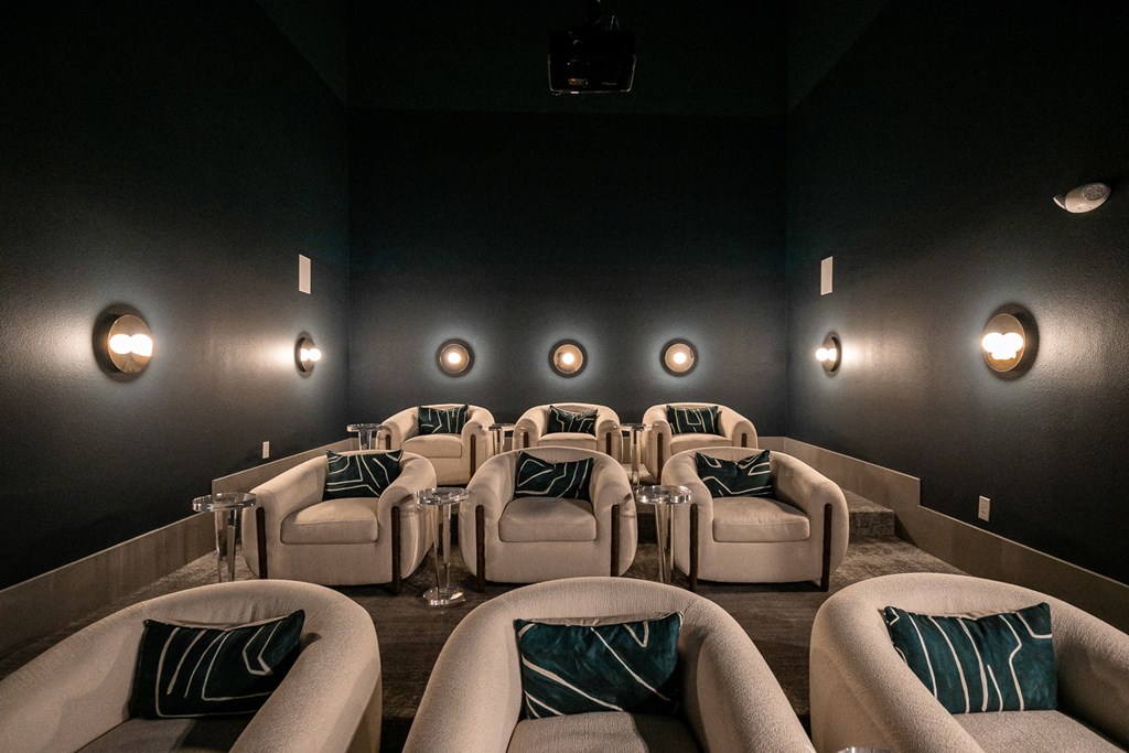 a home theater room with couches and chairs and lights