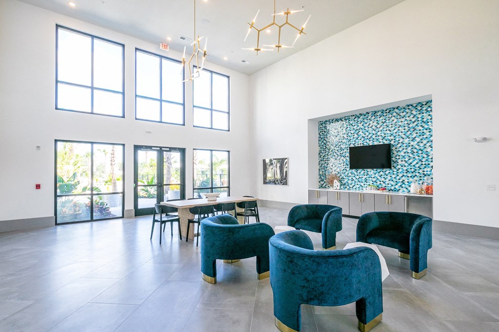a living room with blue chairs and a table and a tv