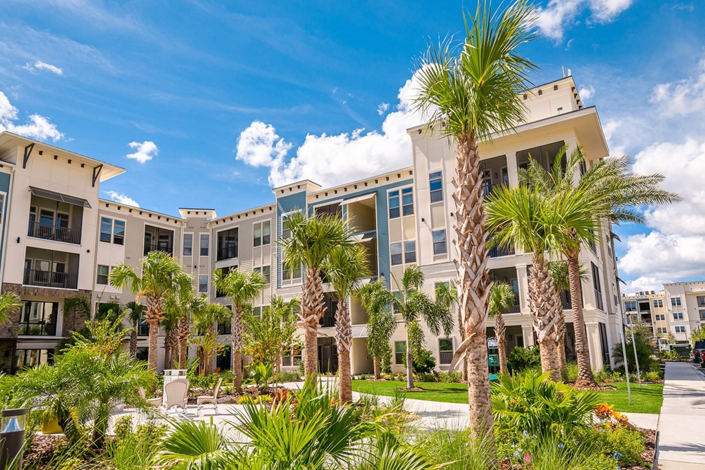 an apartment building with palm trees in front of it