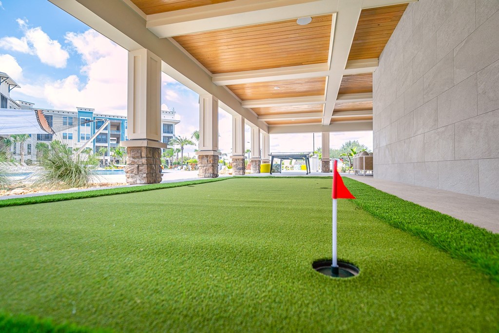 a putting green in a house with a red flag on it