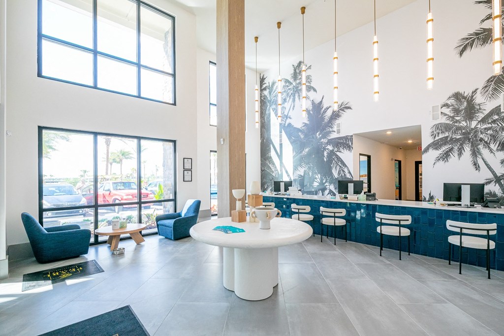 a large lobby with a white table and chairs and a bar with chairs and tables