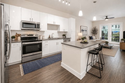 A modern kitchen with white cabinets and a large island.