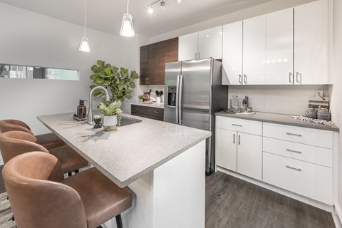 A modern kitchen with a table and chairs.