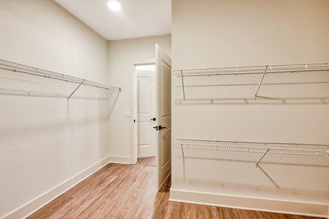 a bedroom with white walls and wood flooring