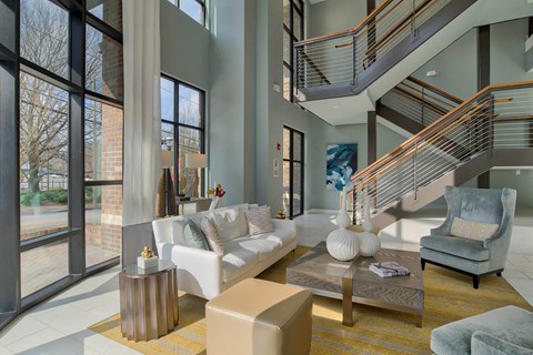 a living room with a white couch and a staircase