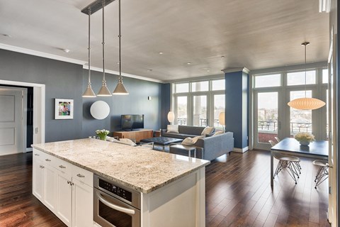 a kitchen with an island and a living room with a couch and a tv