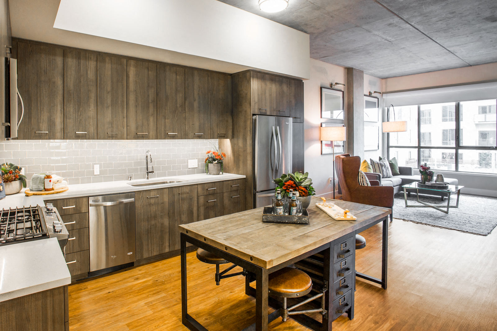 a kitchen and living room with a wooden table and a sink