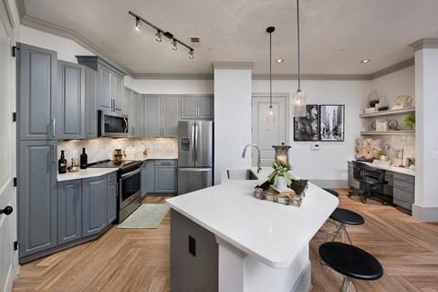 a kitchen with gray cabinets and a white counter top