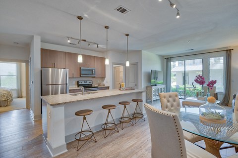 a kitchen with a bar and a dining table with chairs