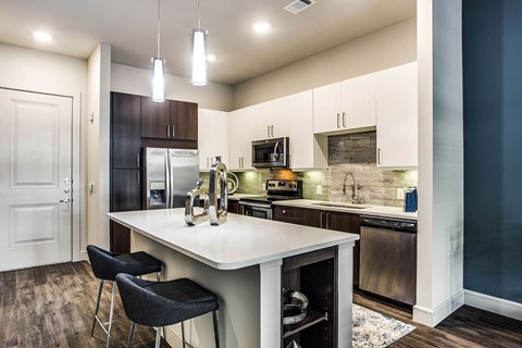 a kitchen with a large island with two chairs