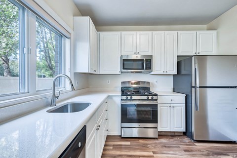 a kitchen with white cabinets and stainless steel appliances
