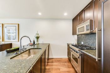 Kitchen with Granite Countertops and Espresso Cabinetry at The Bravern, 688 110th Ave NE, Bellevue