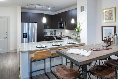 a kitchen with a large island and a table with chairs