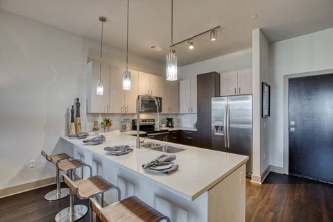 a kitchen with a large island and a stainless steel refrigerator