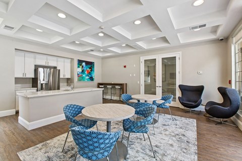 a living room with a kitchen and a table and chairs