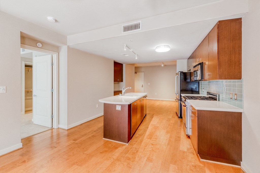 a kitchen and living room with hardwood floors and white walls