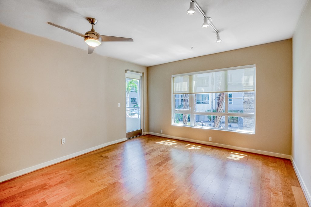 a bedroom with hardwood floors and a ceiling fan