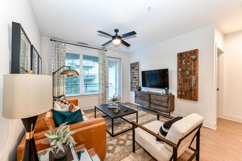 a living room with a ceiling fan and a tv