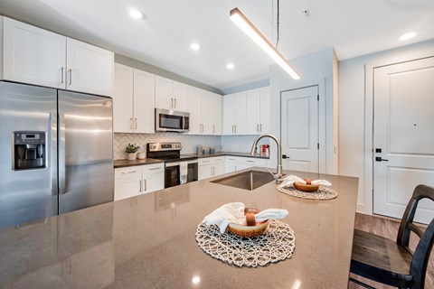 a large kitchen with stainless steel appliances and white cabinets