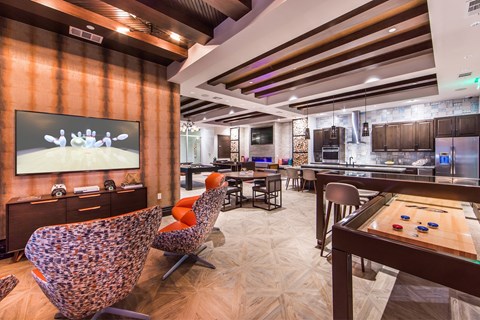 a living room with a tv and a table with chairs and a billiards