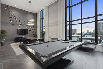 a billiards table in a game room with a view of the city at The Sterling at Regent Square, Houston, TX
