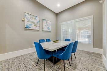 a meeting room with a white table and blue chairs