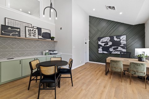 A dining room with a black table and chairs.