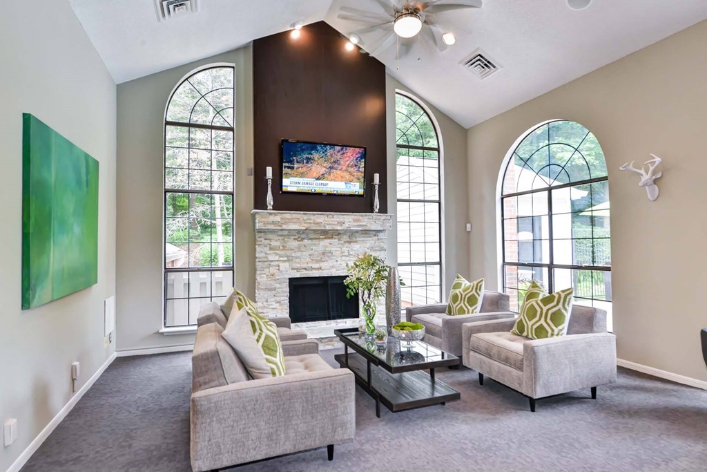 Windsor Oak Creek - Clubroom with couches and a coffee table in front of a fireplace in Fairfax VA