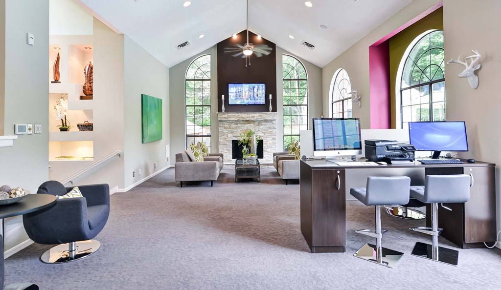 Windsor Oak Creek - Community Clubroom with couches and a coffee table in front of a fireplace in Fairfax VA