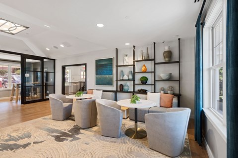 a living room with chairs and tables and a large window