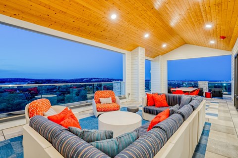 a living room with blue and orange furniture and a view of the ocean