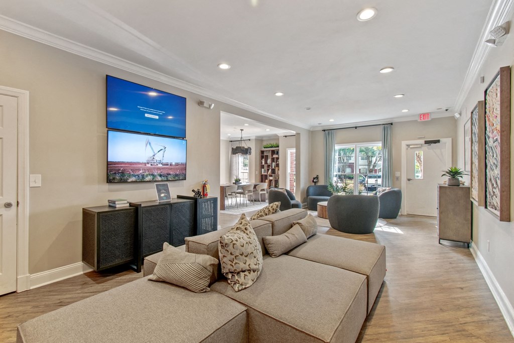 A living room with a large couch and a television mounted on the wall.