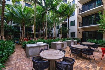 Outdoor patio with tables and chairs at Windsor Ludlam Trail, an apartment complex in Miami, FL.