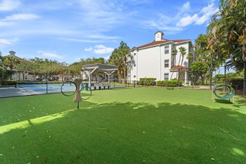 a grassy area next to a swimming pool with a gazebo
