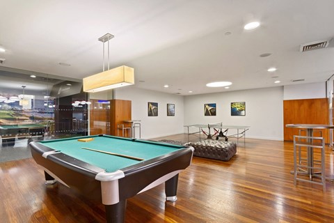 A pool table is in the middle of a room with a green felt cloth.